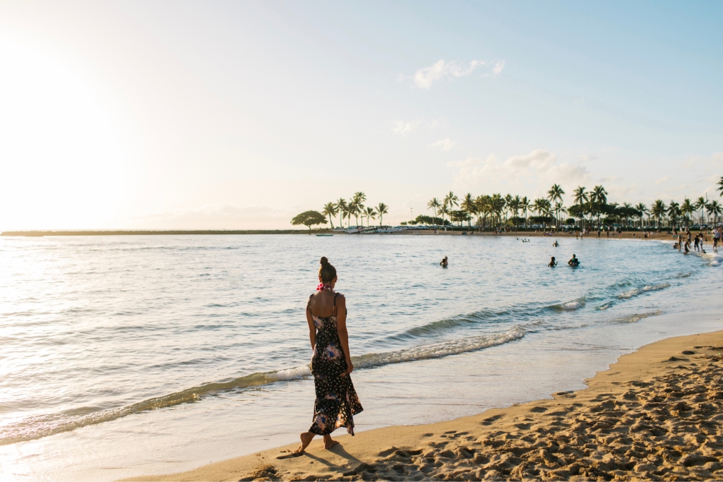 A woman walks along Waikiki Beach