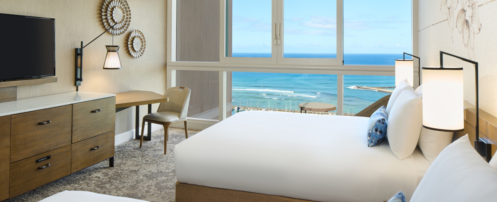 Two hotel beds looking out to ocean view