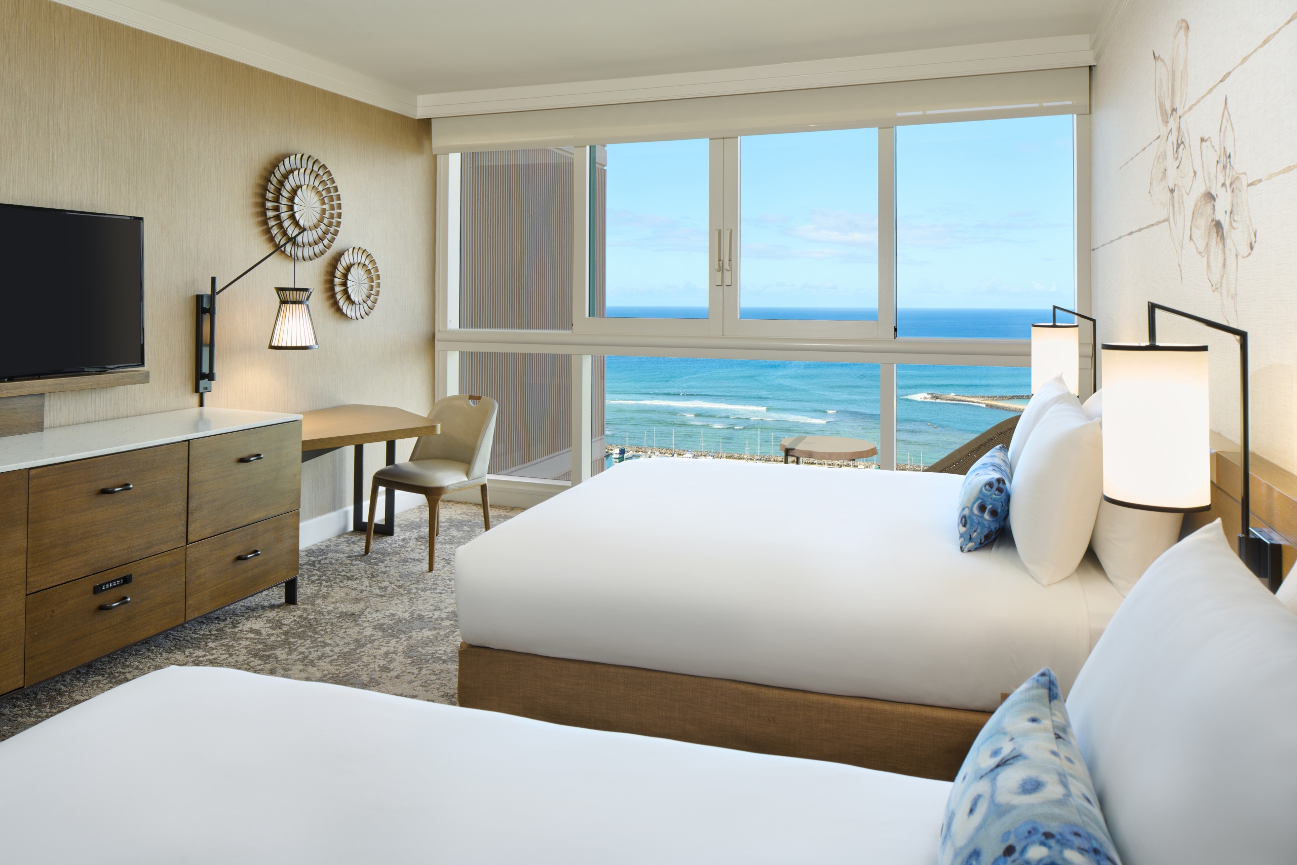 Two hotel beds looking out to ocean view