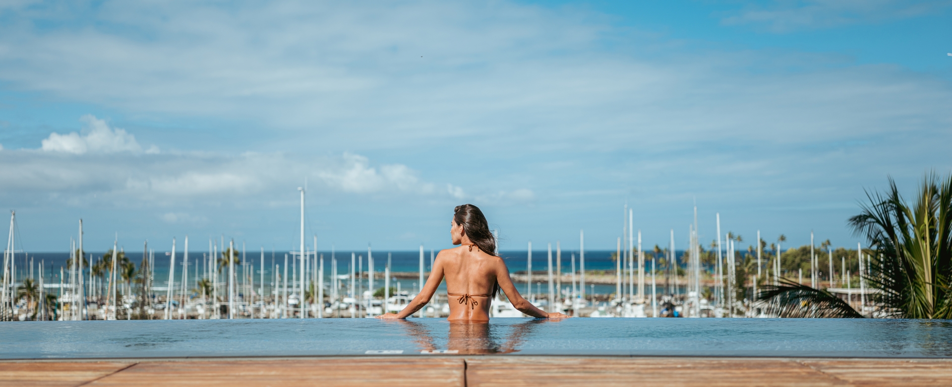 A woman looks out on the water from the Prince Waikiki infinity pool