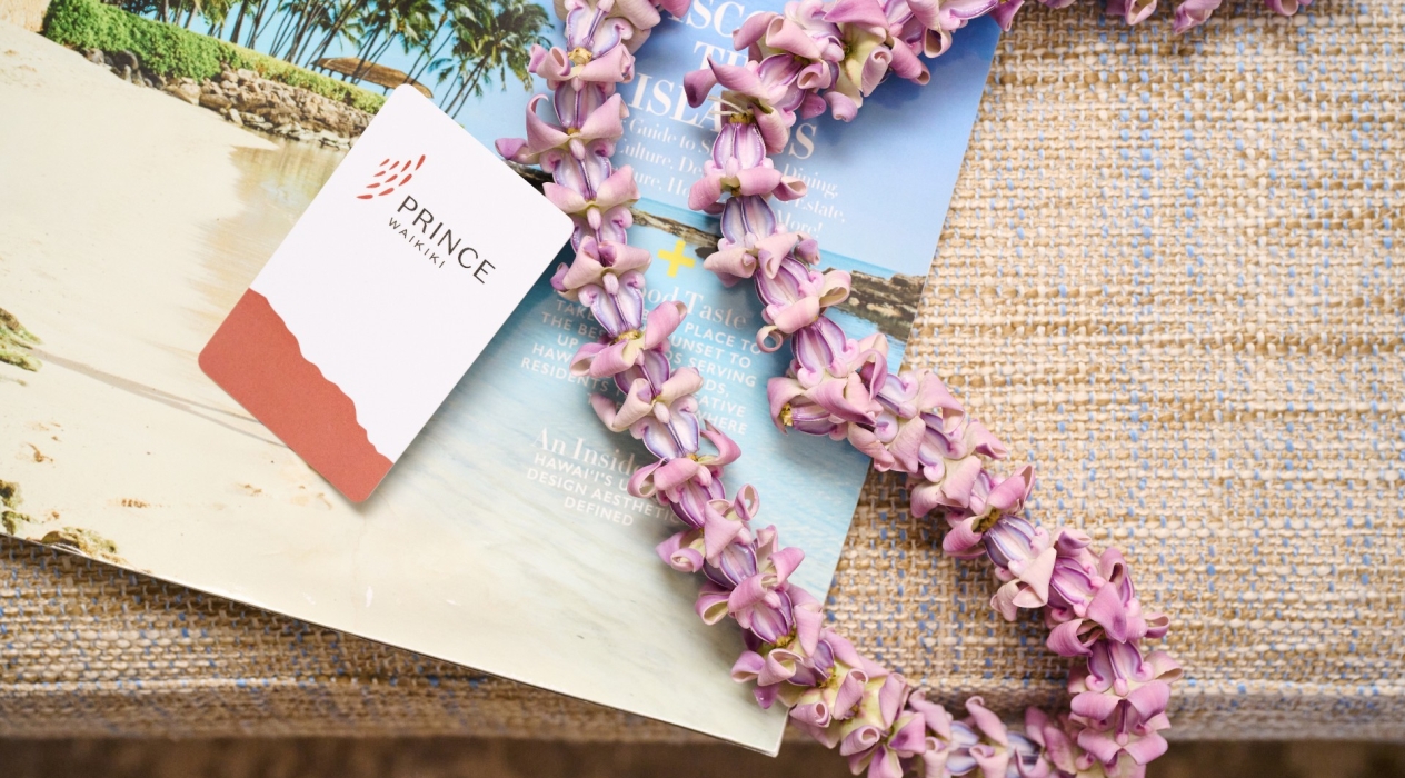 Room key and flower necklace on a strawgrass placemate
