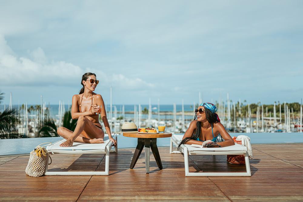 Friends relax by the pool at Prince Waikiki in Honolulu