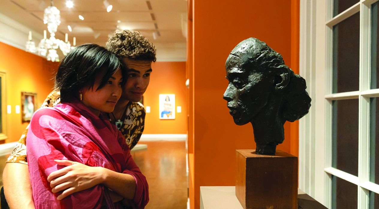 A couple looking at a face sculpture at the Honolulu Museum of Art (HoMA) in Honolulu, HI.