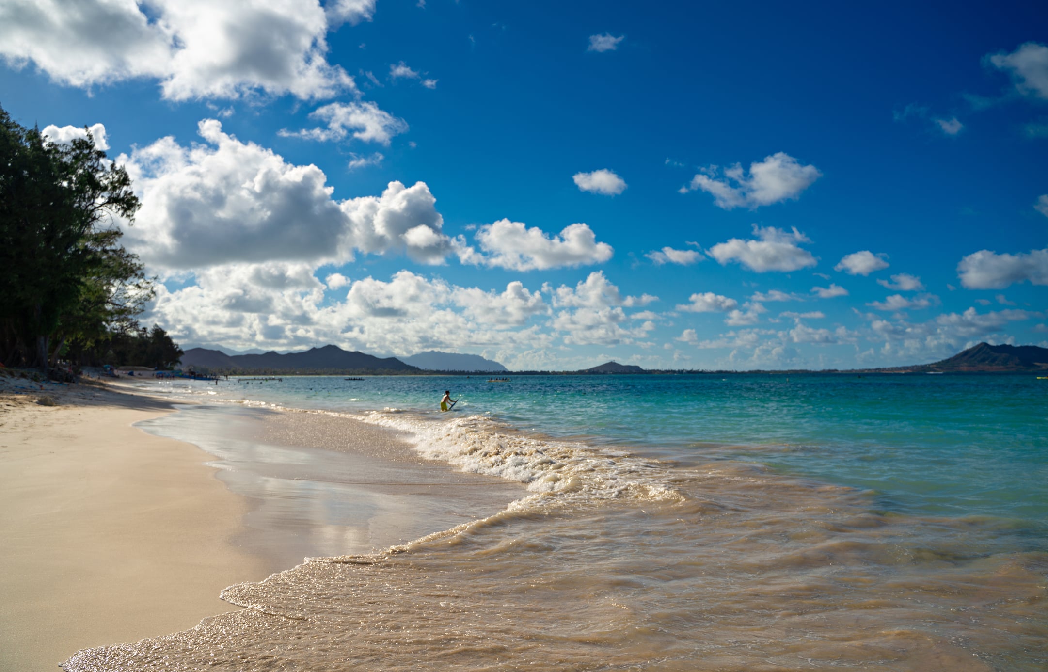 A person plays in the waves at Kailua Beach in Hawaii.