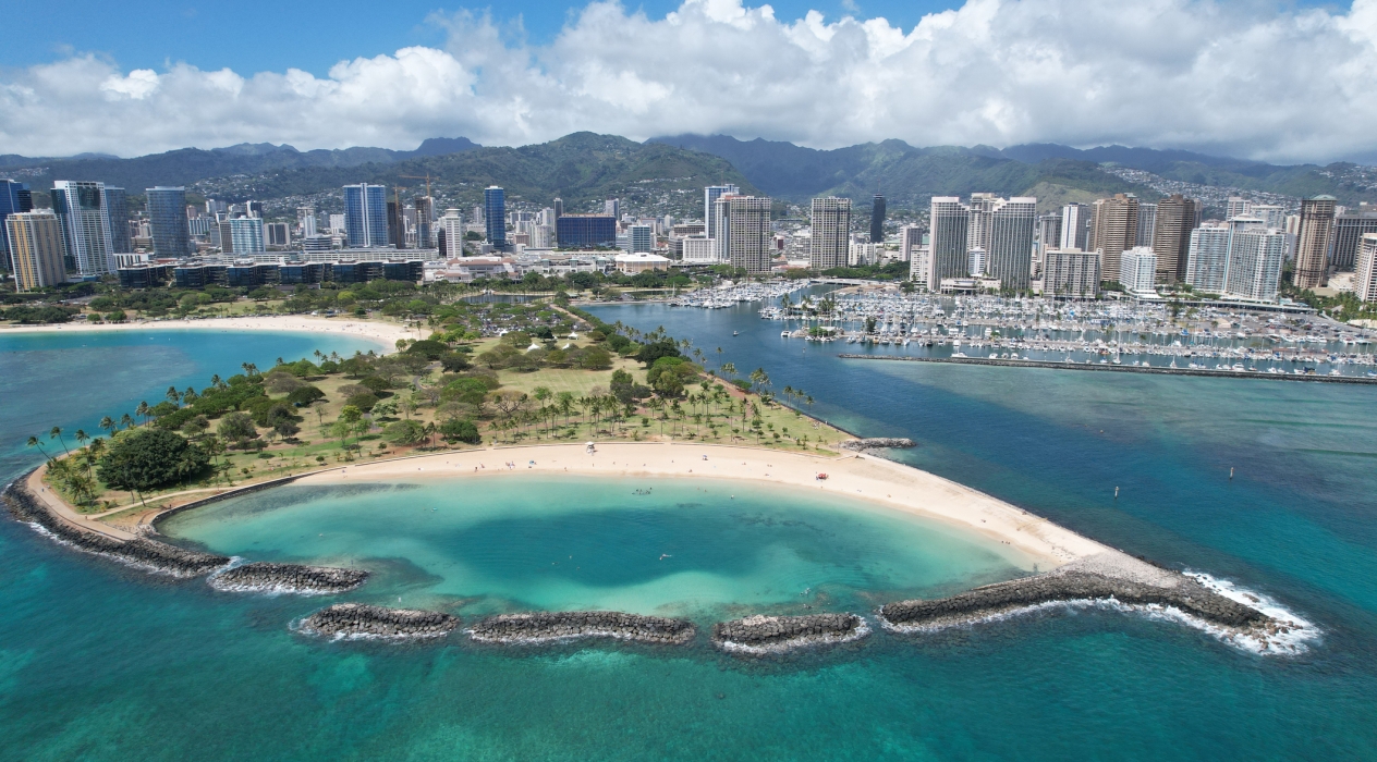 Drone shot above Magic Island at Ala Moana Beach with the Ala Wai Boat Harbor in background