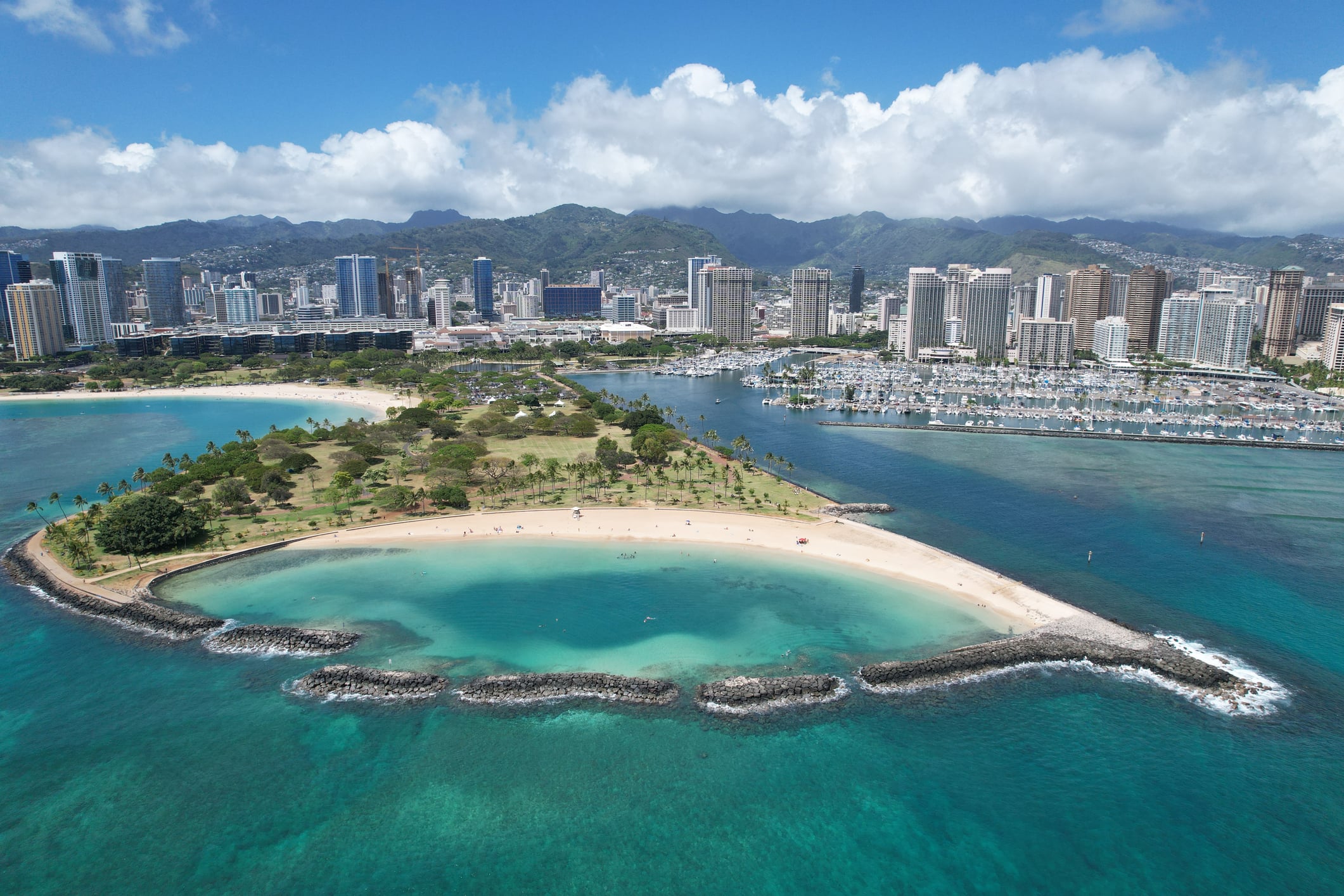 Drone shot above Magic Island at Ala Moana Beach with the Ala Wai Boat Harbor in background