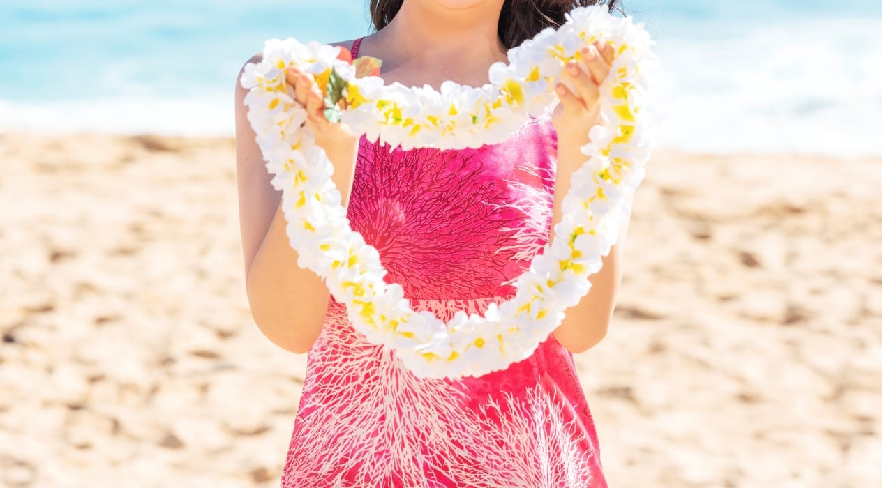 Aloha greeting with Hawaii flower lei on the beach