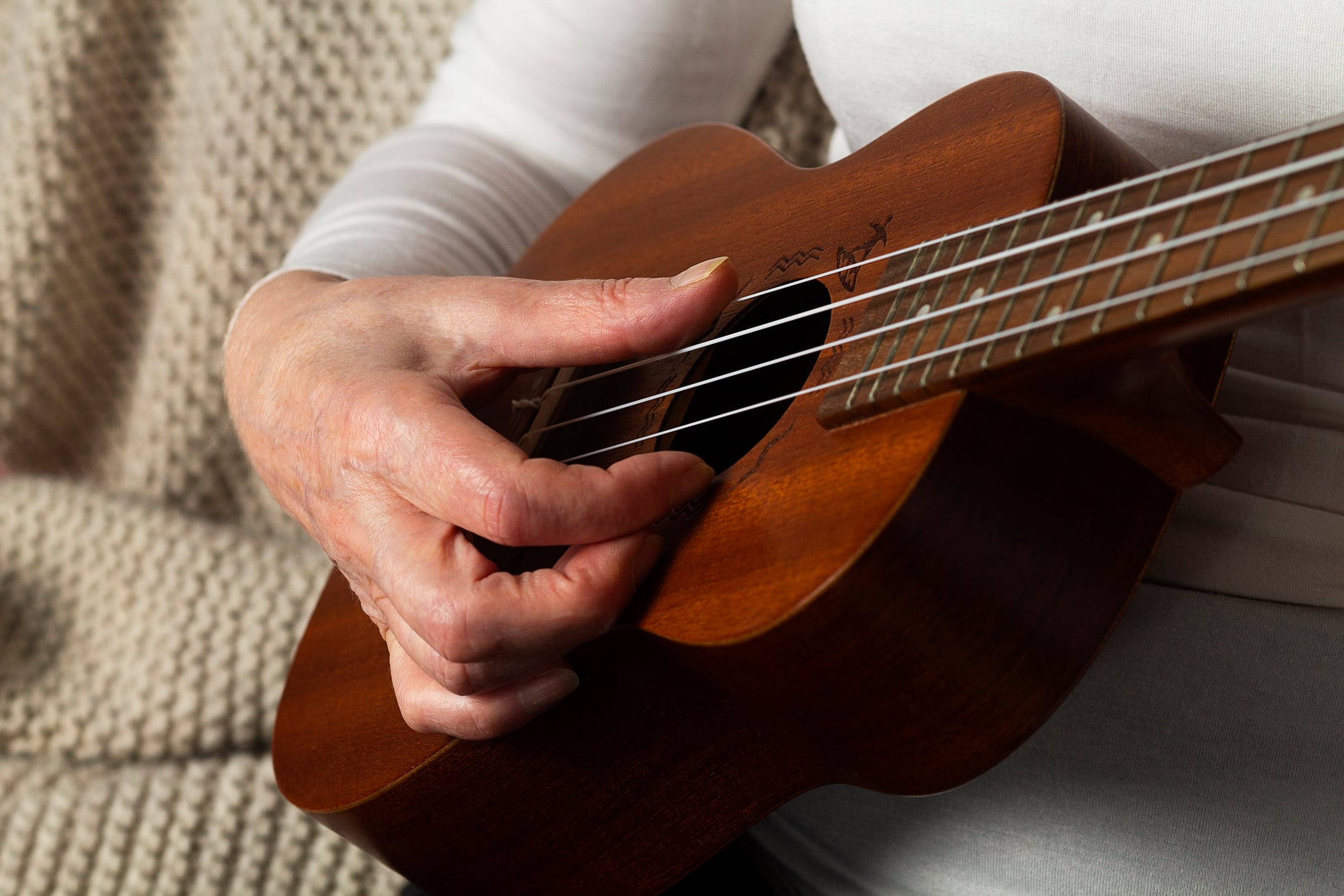 Close-up of hands playing guitar. musician playing hawaiian ukulele.